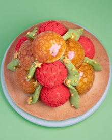 Top view of choux puffs with red craquelin and caramel glaze assembled into a Christmas tree dessert.